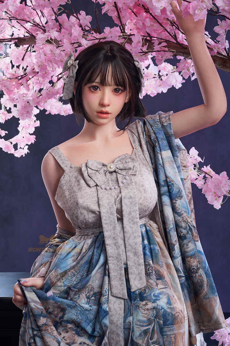 Sex doll im leichten Kleid mit asiatischem Stil und natürlicher Optik unter Kirschblüten
