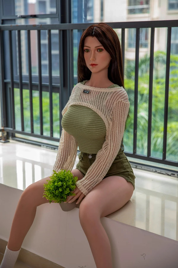 Lebensechte Love doll Aerith im olivgrünen Outfit mit kleiner Pflanze