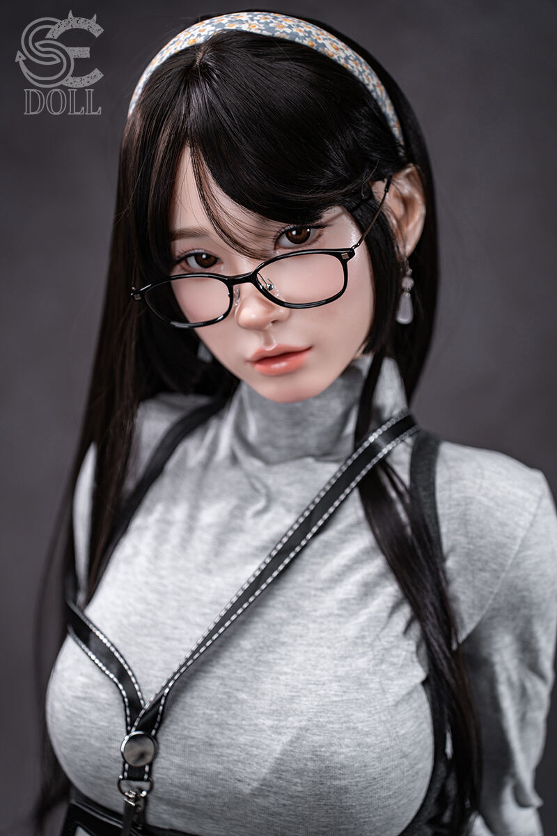 Elegante lebensechte asiatische Puppe mit Brille