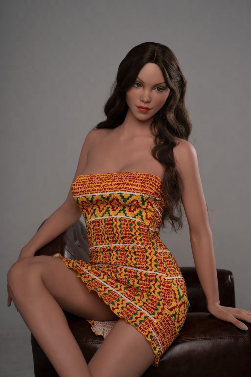 Realistische lebensgroße Sexpuppe Andy im orangefarbenen Kleid auf Sessel sitzend